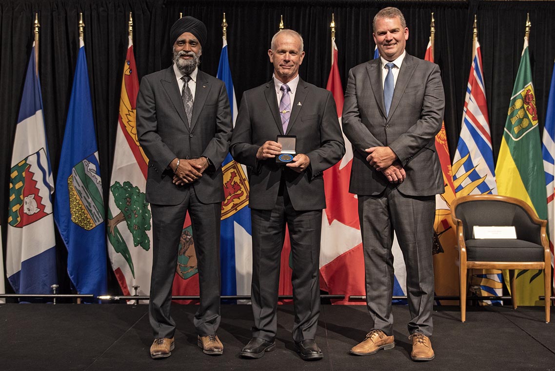 The Honourable Harjit S. Sajjan, President of the King's Privy Council for Canada and Minister of Emergency Preparedness (far left) and Minister responsible for the Pacific Economic Development Agency of Canada, and the Honourable Bloyce Thompson, Deputy Premier, Minister of Justice and Public Safety and Attorney General for Prince Edward Island (far right) are pictured with the 2022 award recipient of the Emergency Management Exemplary Service Award for the Outstanding Contribution to Emergency Management category.