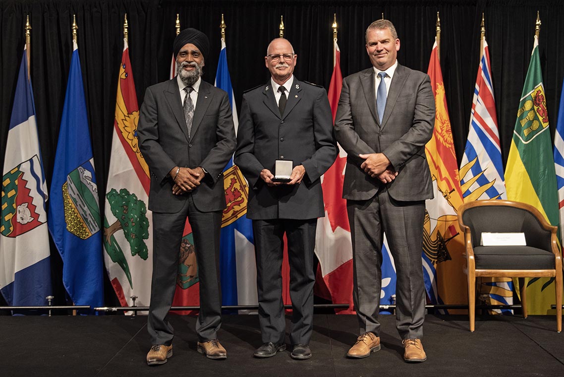 The Honourable Harjit S. Sajjan, President of the King's Privy Council for Canada and Minister of Emergency Preparedness (far left) and Minister responsible for the Pacific Economic Development Agency of Canada, and the Honourable Bloyce Thompson, Deputy Premier, Minister of Justice and Public Safety and Attorney General for Prince Edward Island (far right) are pictured with the 2022 award recipient of the Emergency Management Exemplary Service Award for the Outstanding Contribution to Emergency Management category.
