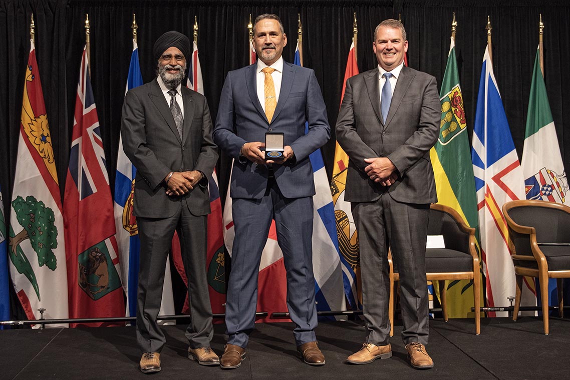 The Honourable Harjit S. Sajjan, President of the King’s Privy Council for Canada and Minister of Emergency  Preparedness (far left) and Minister responsible for the Pacific Economic  Development Agency of Canada, and the Honourable Bloyce Thompson, Deputy  Premier, Minister of Justice and Public Safety and Attorney General for Prince  Edward Island (far right) are pictured with the 2022 award recipient of the  Emergency Management Exemplary Service Award for the Outstanding Contribution  to Emergency Management category.